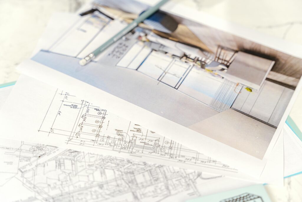 Close-up of architectural blueprints and 3D design on paper with pencil on a desk.